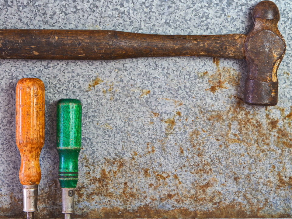 Hammer and screwdrivers on a metal bench